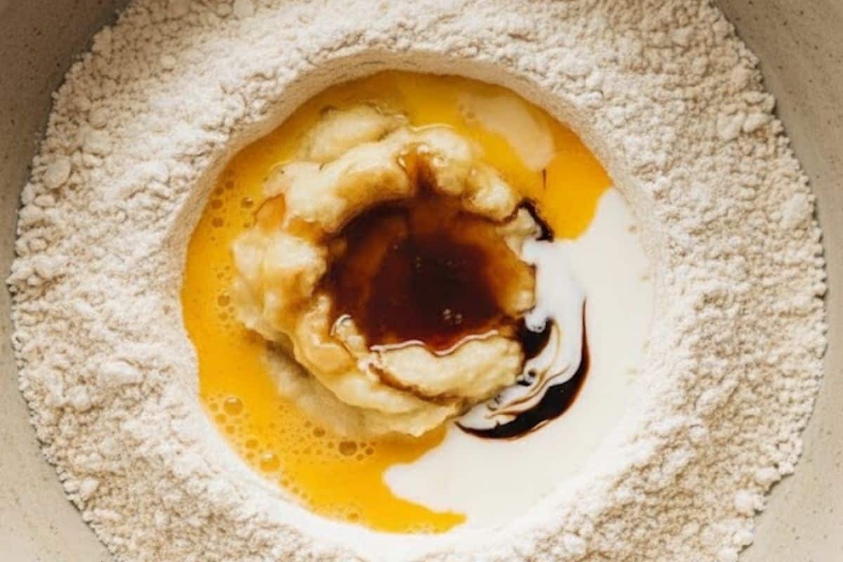 Pour the mashed bananas, eggs, maple syrup, melted butter, milk, and vanilla