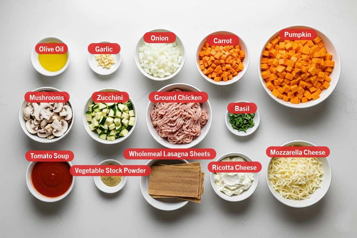 Top shot of ingredients: olive oil, garlic, onion, carrot, pumpkin, mushroom, zucchini, ground chicken, basil. tomato soup, vegetable sTock powder, wholemeal lasagna sheets, ricotta cheese, and mozzarella cheese.