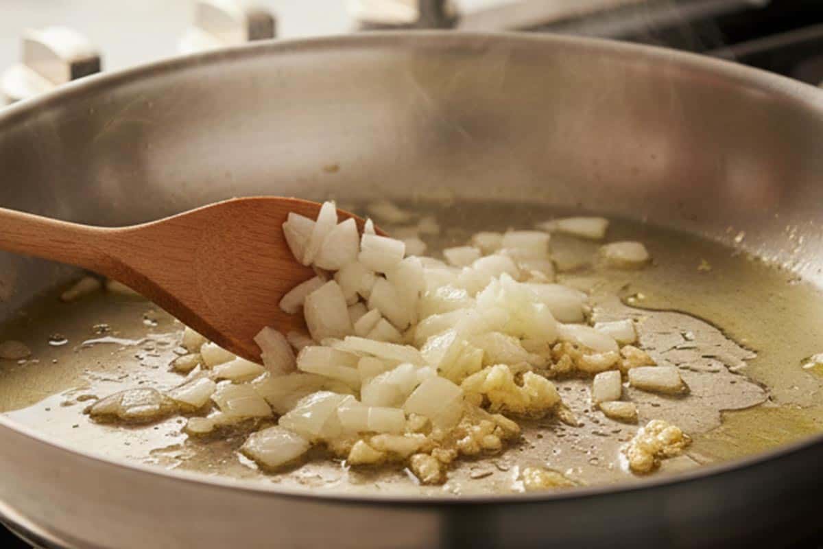 Sautéing the onion and garlic in a pan.