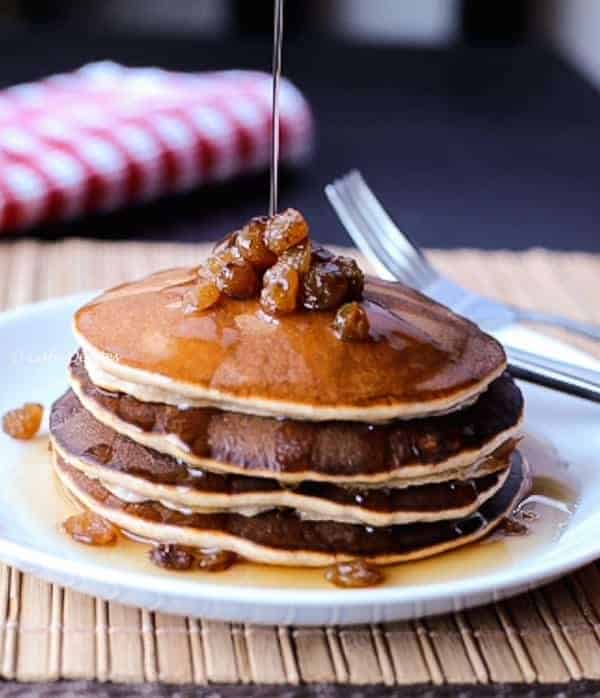 Maple syrup being poured over Cinnamon Raisin Pancakes