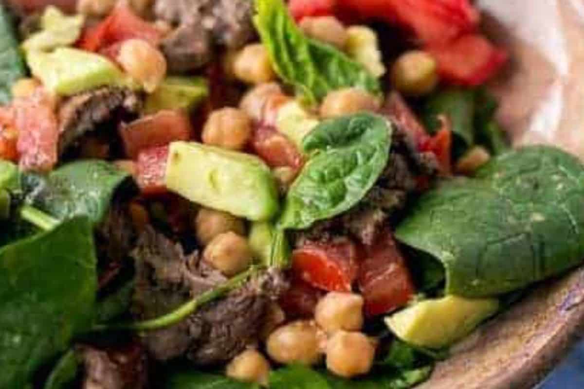 Season the salad with salt and pepper, then place the warm lamb and diced avocado on top