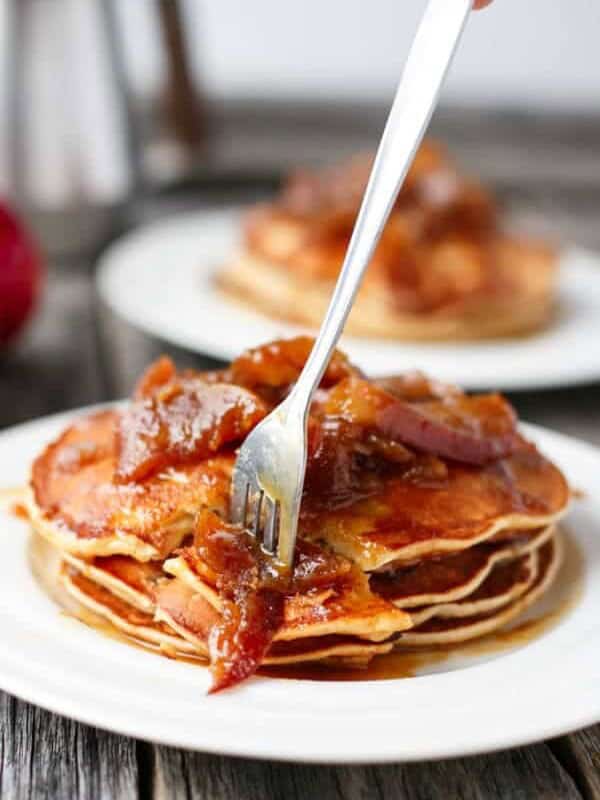 A fork pierced in Caramel Apple Pancakes on a plate