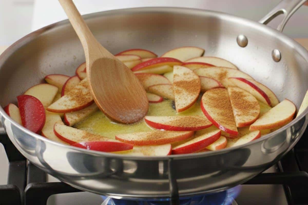 Cooking the apples, butter, sugar, cinnamon, and vanilla in a pan.