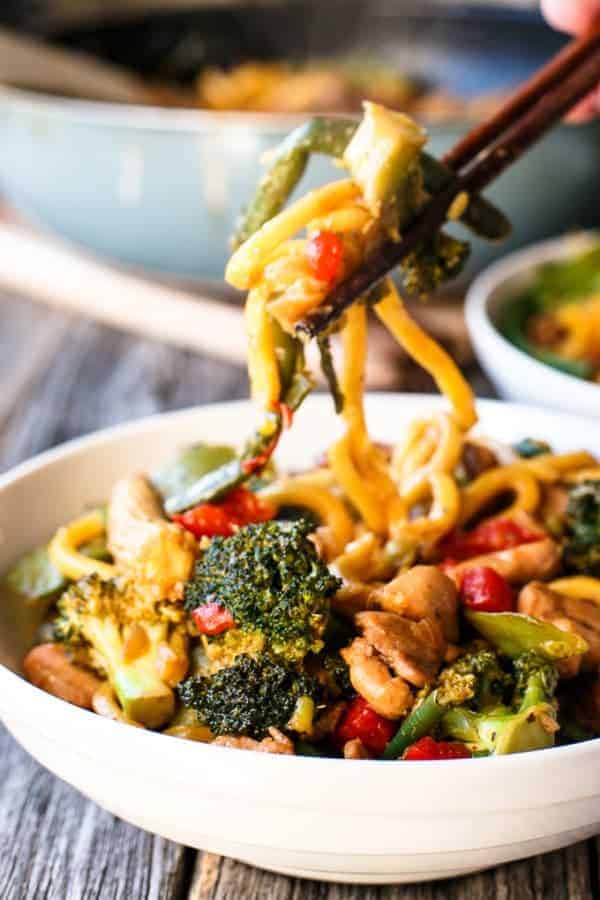 Some Chicken Noodle being pulled by chopsticks from the bowl