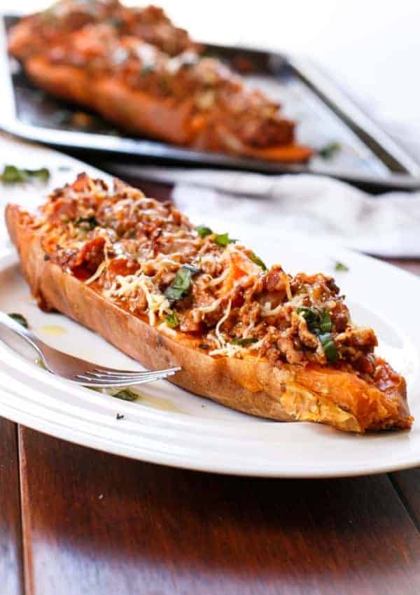 Bacon Bolognese Stuffed Sweet Potatoes with fork on a plate