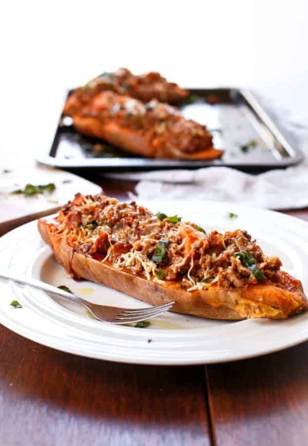 Bacon Bolognese Stuffed Sweet Potatoes on a plate and 2 pieces on baking tray