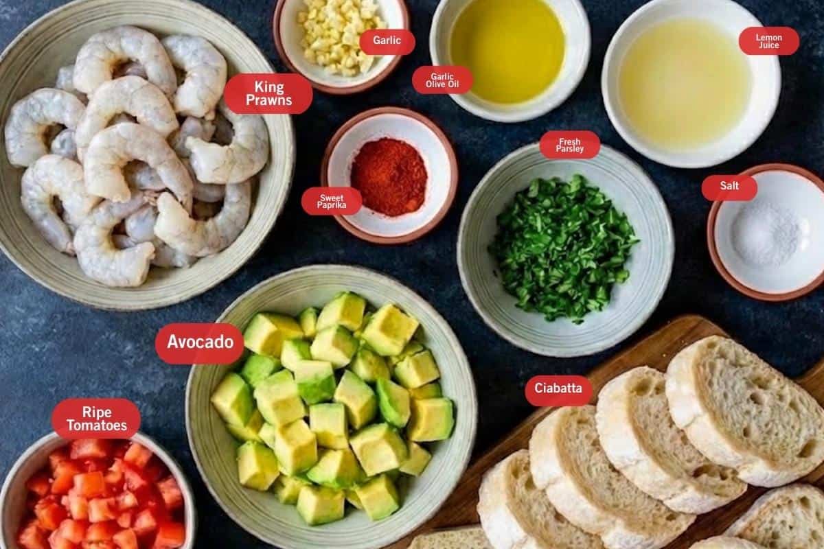 Flat lay photo of ingredient shot of king prawns, garlic, garlic olive oil, lemon juice, salt, ciabatta, fresh parsley, ripe tomatoes, avocado, sweet paprika