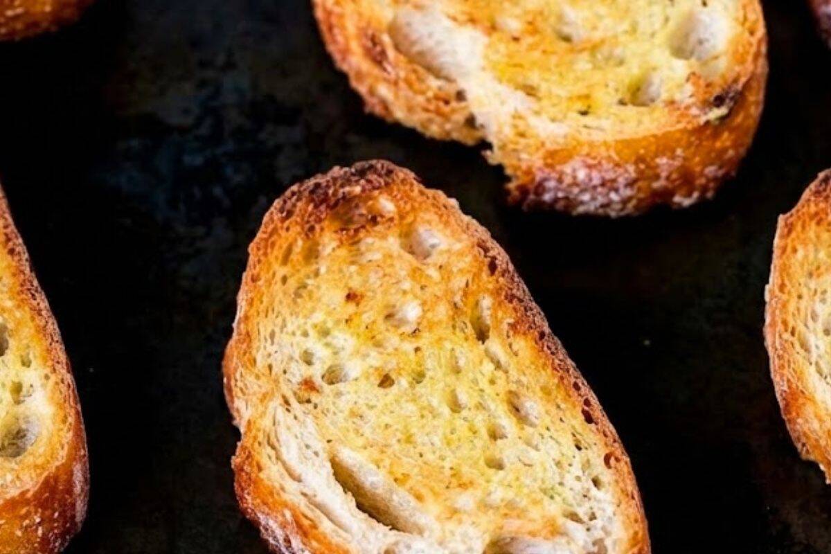 Preheat your grill or broiler to medium high, arrange the bread slices on a lightly greased tray, and toast until golden and crisp.