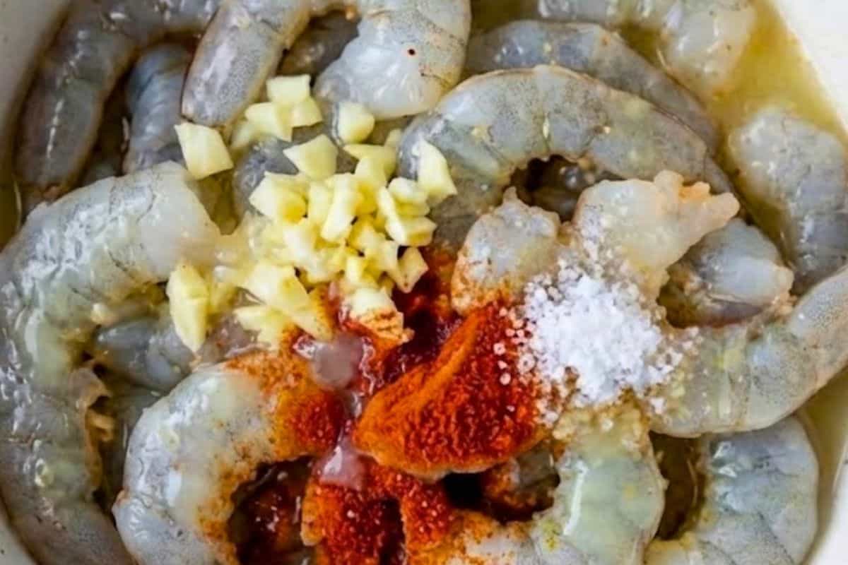 In a bowl, toss the prawns with garlic, paprika, and lemon juice.
