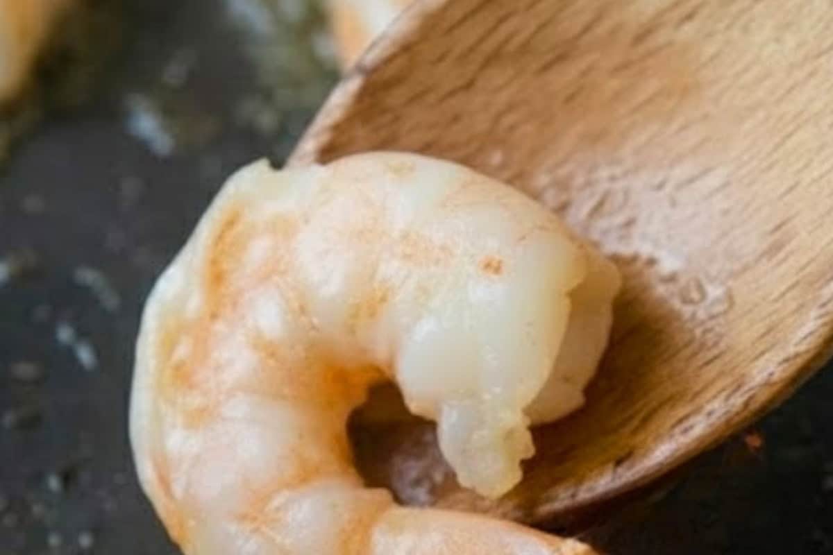 Heat the garlic olive oil in a wide skillet over medium high, add the prawns and cook.