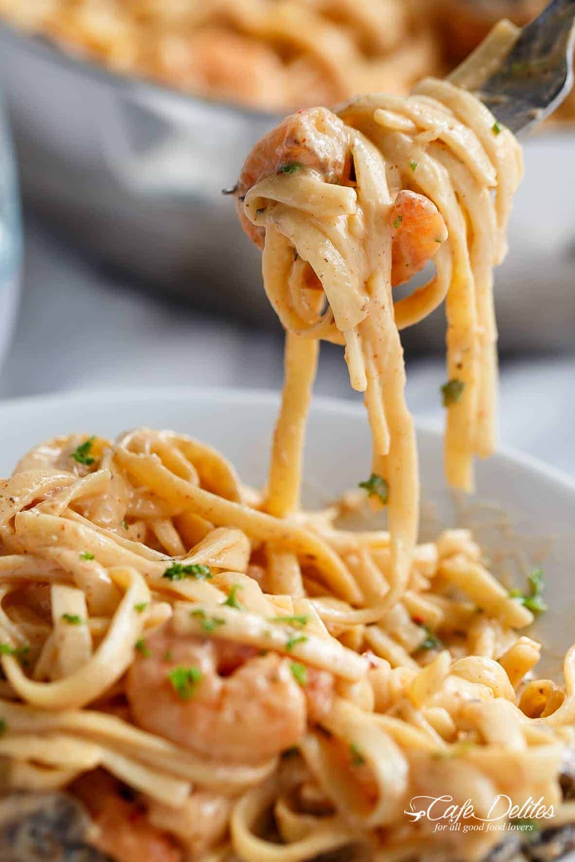 Fork carrying Shrimp Pasta in a creamy garlic parmesan Alfredo sauce!