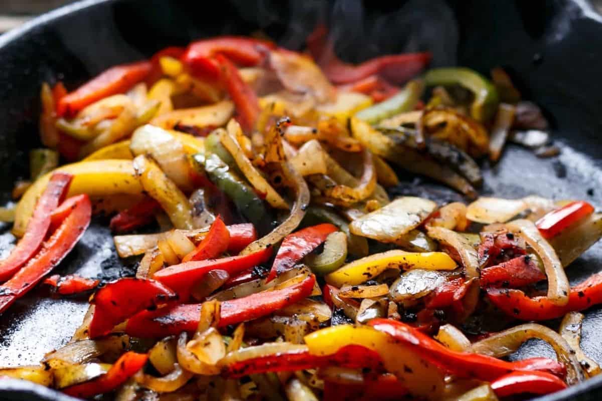 Heat a skillet with a little oil over medium high heat and cook the peppers and onion until vibrant
