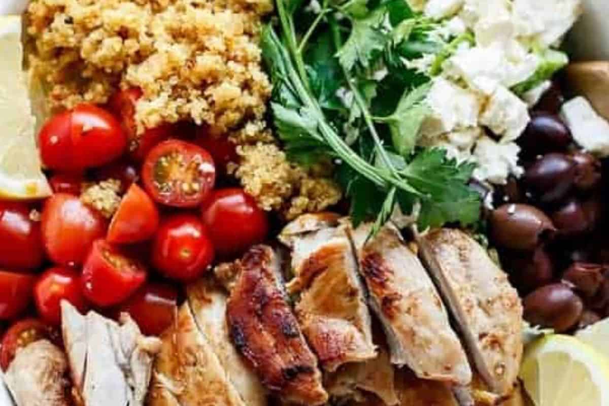 Add lettuce, tomatoes, onion, olives, feta and parsley to a bowl. Top with chicken and quinoa, drizzle with dressing and toss gently to combine.