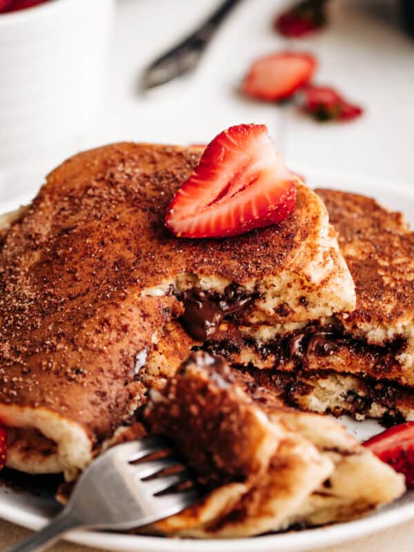 A slice of strawberry on a Chocolate Stuffed Churro Pancakes.