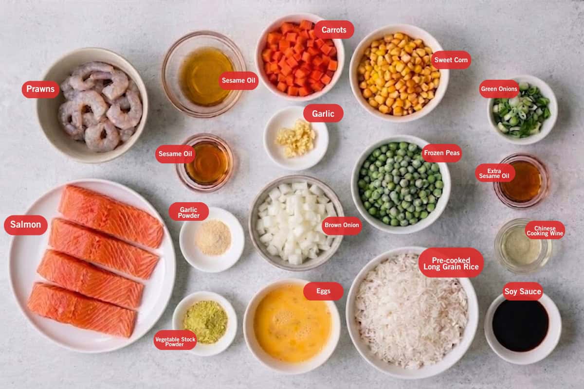 Top shot of ingredients: salmon fillets, prawns, rice, green onions, onion, eggs, carrots, sweet corn, peas, vegetable stock powder, garlic powder, garlic, sesame oil, chinese cooking wine, and soy sauce.