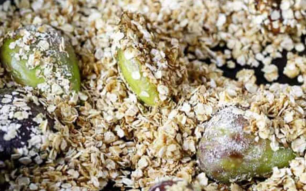 raw oats sprincked over the caramelized figs in a pan