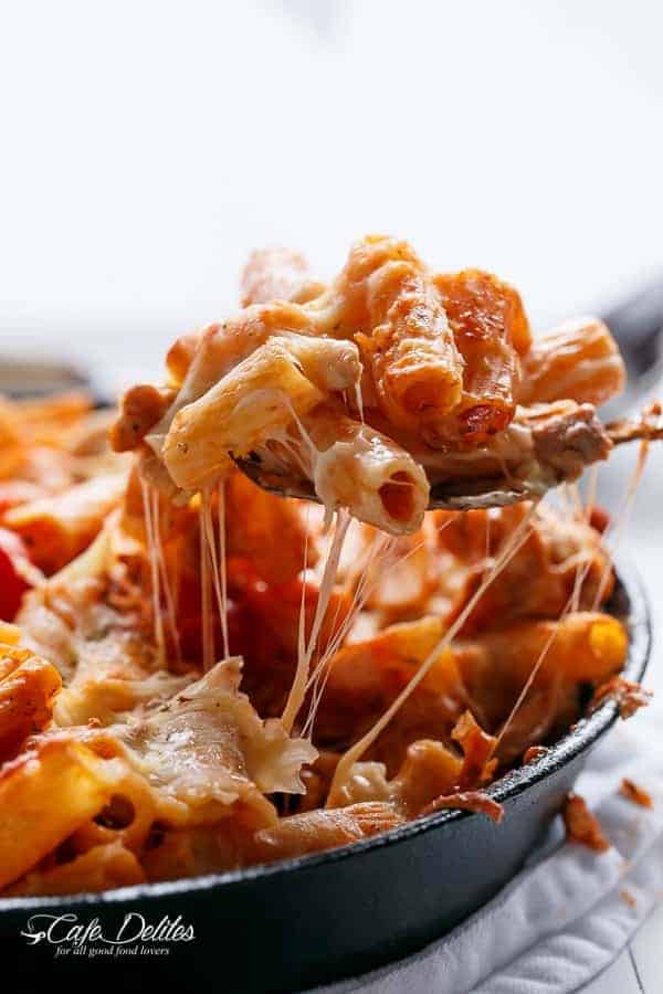 A spoon carrying some pasta from Cheesy Chicken and Roasted Tomato Mozzarella Pasta Bake