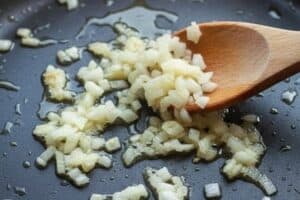Heat olive oil in a skillet and cook the onion and garlic until soft and fragrant.