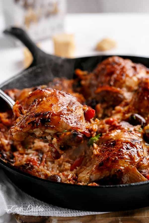 A spoon holding chicken piece from One Pot Italian Sundried Tomato Chicken and Rice
