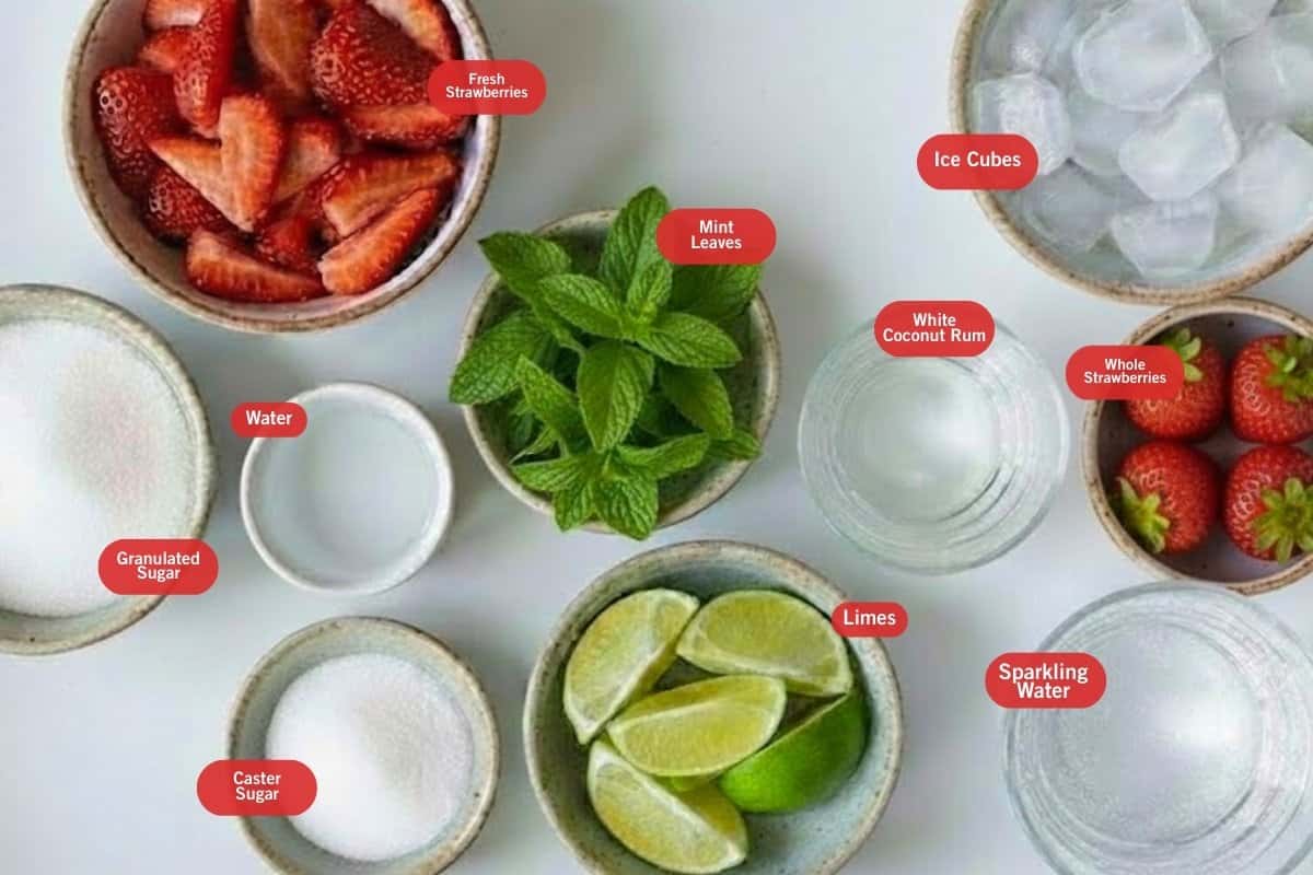Flat lay photo of ingredient shot of fresh strawberries, ice cubes, whole strawberries, mint leaves, white coconut rum, lime, caster sugar, water, granulated sugar, sparkling water