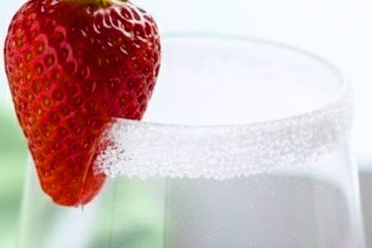Run halved strawberries around the rims of the glasses and dip into sugar