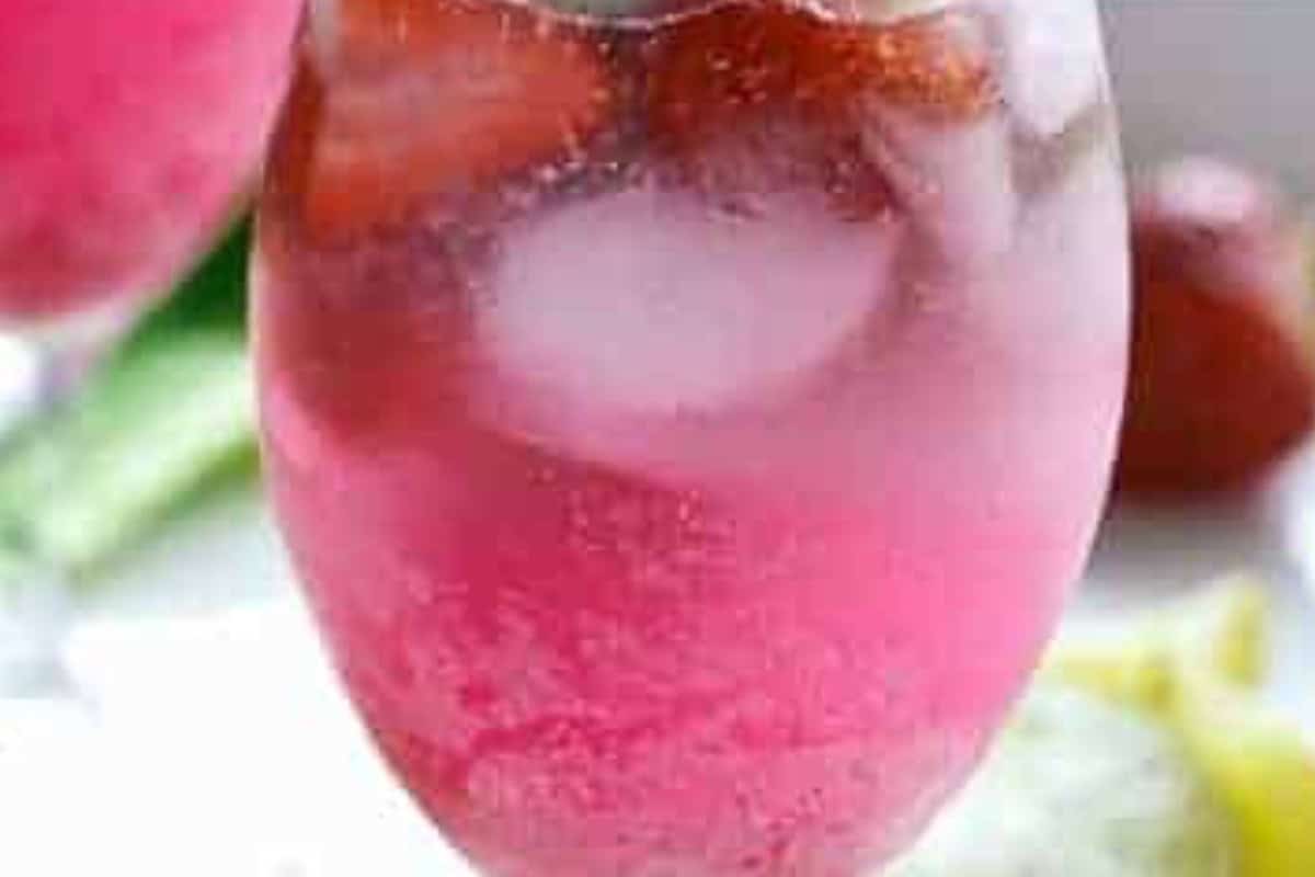 Spoon the cooled strawberry syrup into each glass, add two lime wedges per glass, pour in the coconut rum, and fill with ice.