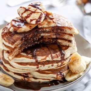 Nutella Stuffed Banana Pancakes stack on each other on a plate