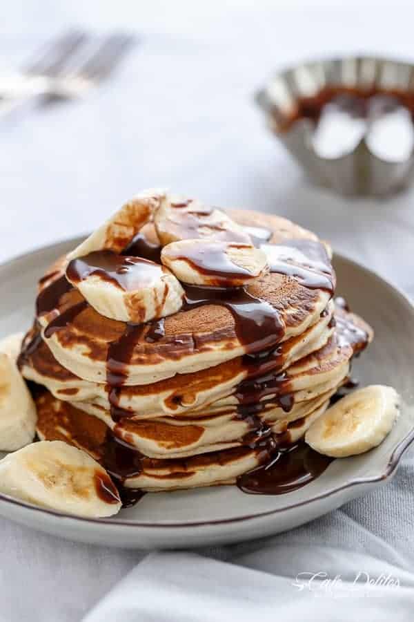Nutella Stuffed Banana Pancakes with maple syrup stack on each other on a plate