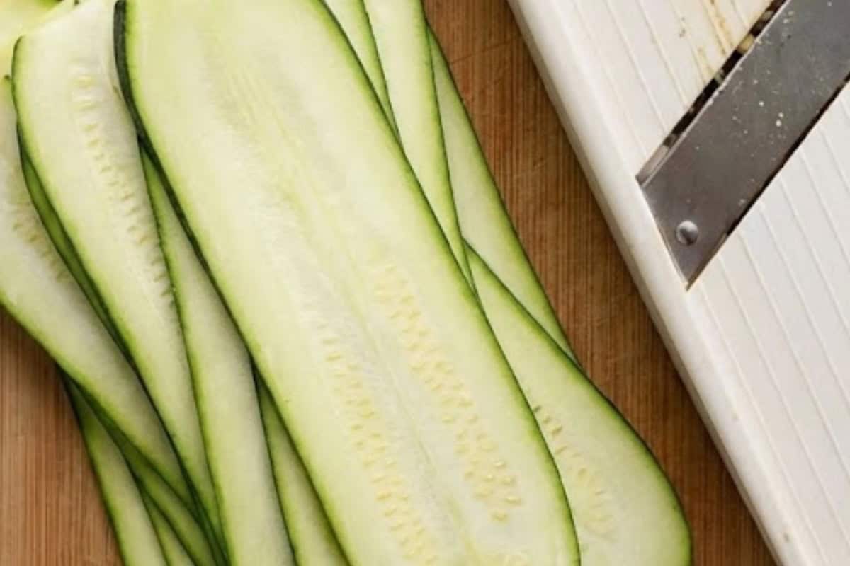 Using a mandolin,slice the zucchini lengthwise into wide ribbons.