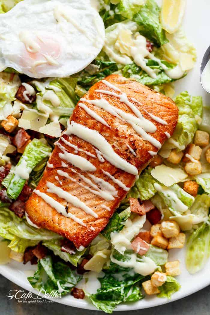 Crispy pan fried Salmon meets Caesar with creamy avocado slices, crunchy croutons, the tang of shaved parmesan cheese, a perfect runny poached egg on top and a lightened up Caesar dressing!