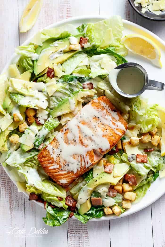 Crispy pan fried Salmon meets Caesar with creamy avocado slices, crunchy croutons, the tang of shaved parmesan cheese, a perfect runny poached egg on top and a lightened up Caesar dressing!