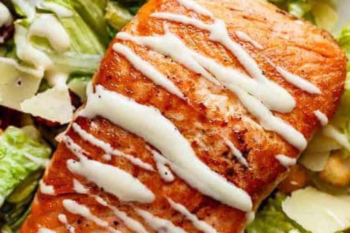 Combine lettuce, salmon, bacon, avocado, parmesan, and croutons. Add dressing, top with eggs, and serve.