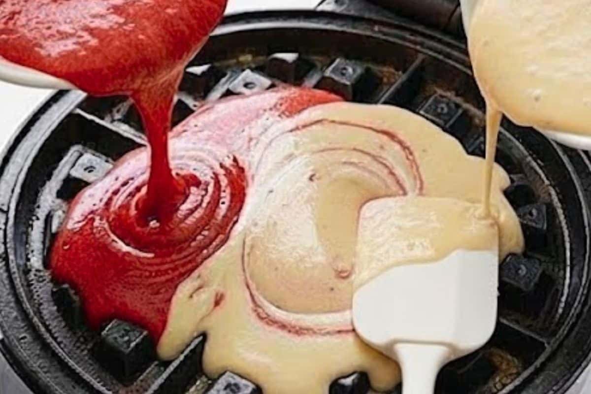 Lightly grease the waffle maker, then pour about 1/4 cup of red velvet batter, followed by 1/4 cup of vanilla batter. Swirl gently with a spatula to create a marbled effect