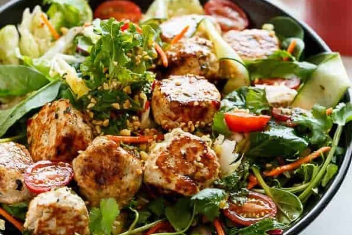 Toss the salad until coated, top with the warm Thai chicken meatballs, then garnish with crushed peanuts