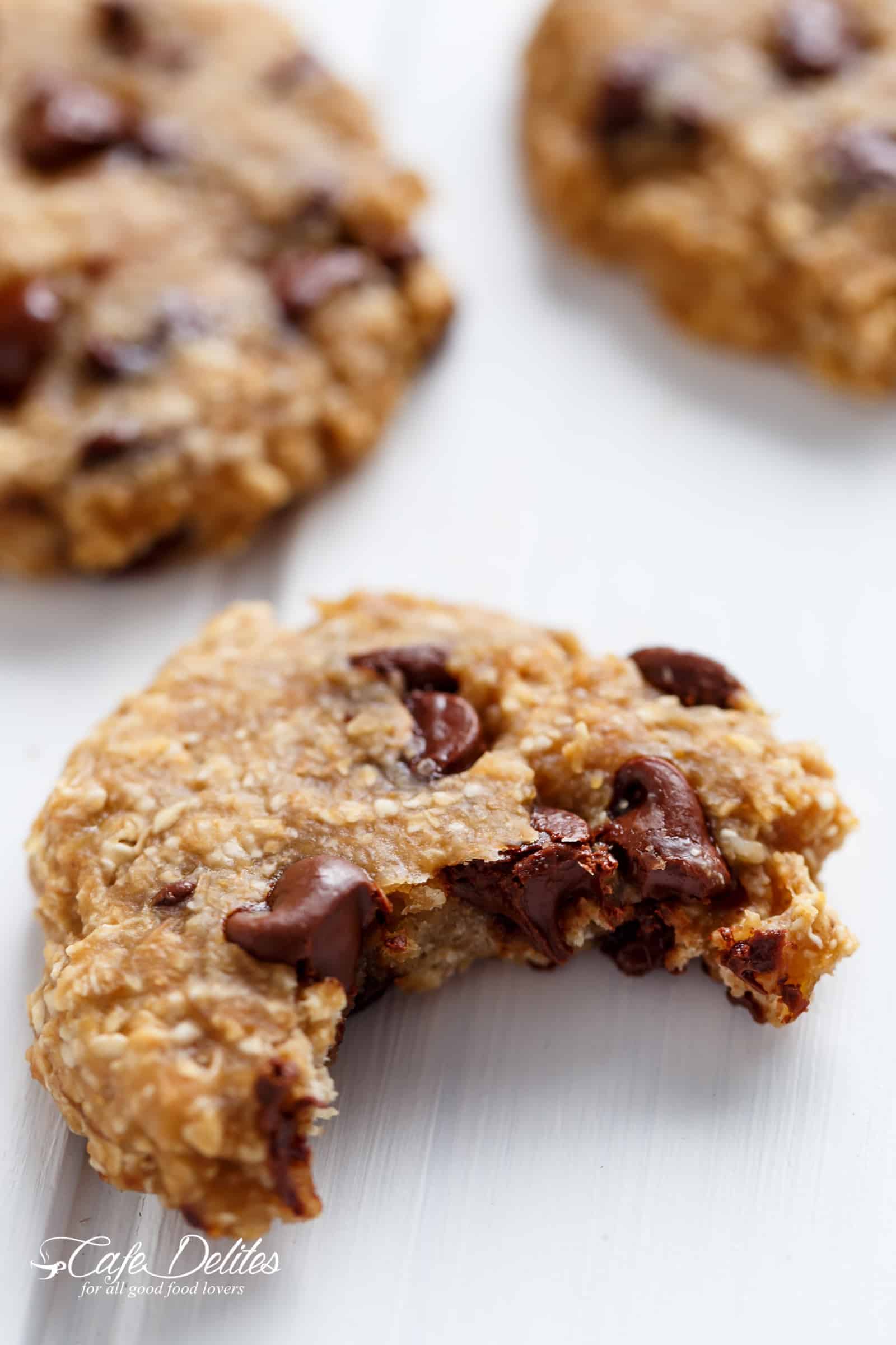 Close-up of a breakfast cookie with a bite missing and chocolate melting from inside.