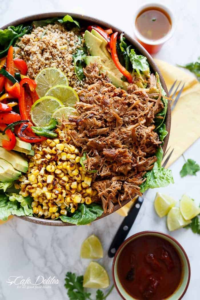 Crispy Carnitas in a salad drizzled with an incredible Chipotle Lime Dressing and a low carb Cilantro Lime Rice! in a pan with some lemon wedges in the background