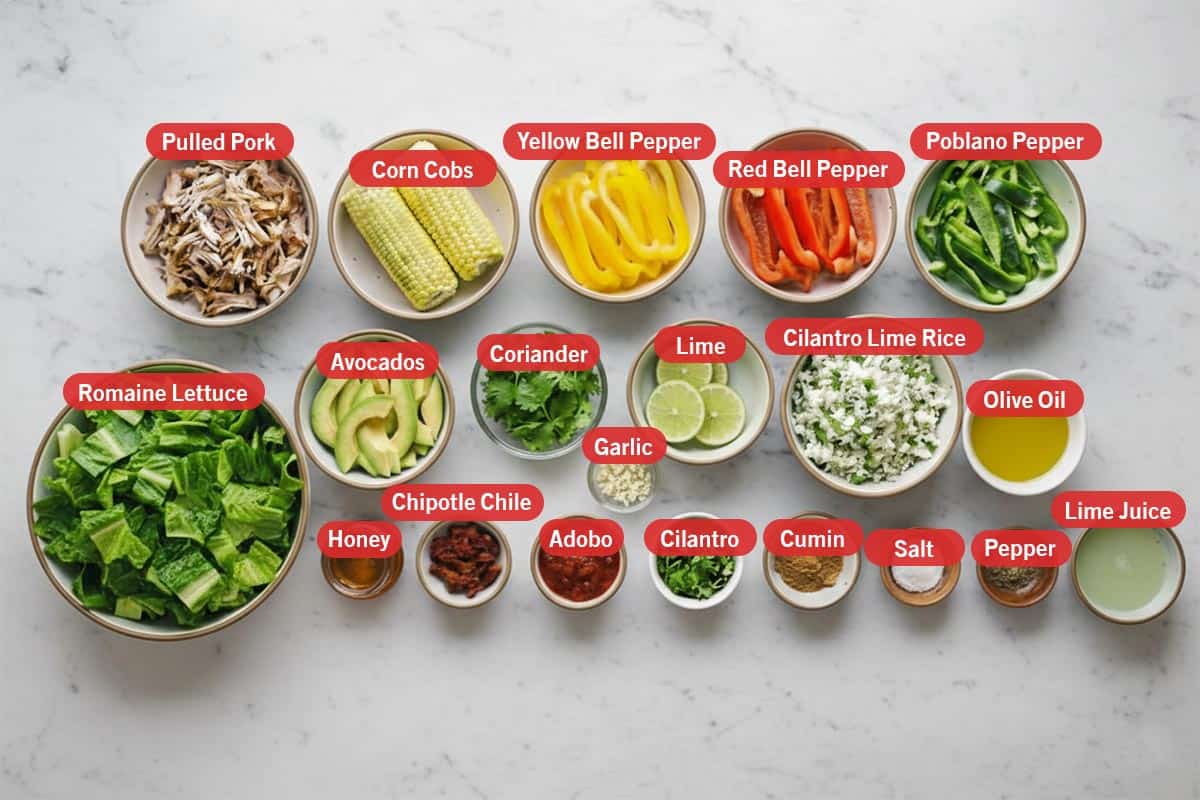 Top shot of ingredients: Pulled pork, corn cobs, yellow bell pepper, red bell pepper, poblano pepper, romaine lettuce, avocados, coriander, lime, cilantro lime rice, olive oil, honey, chipotle chile, adobo, garlic, cilantro, cumin, salt, pepper, and lime juice.