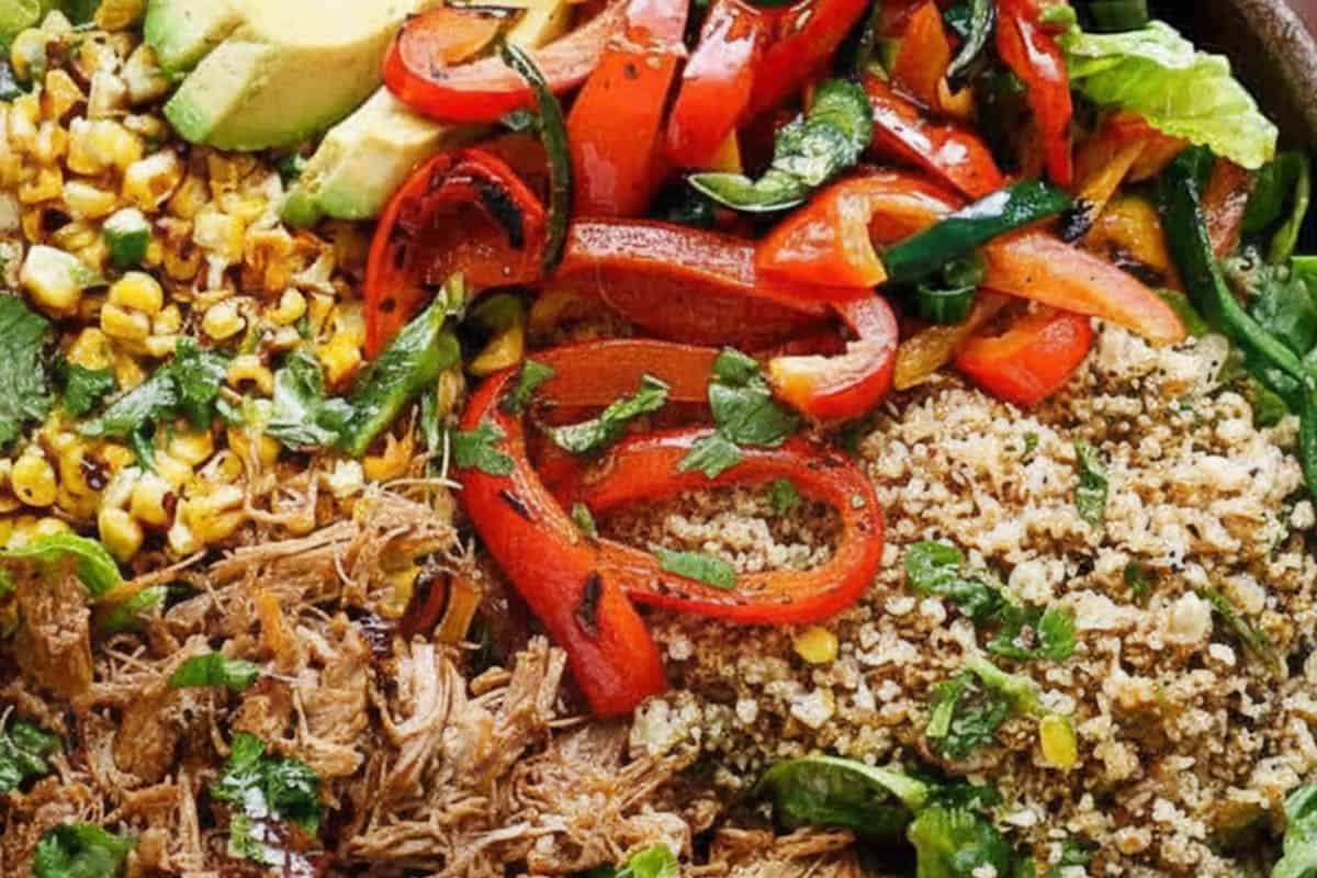 Combined the lettuce, warm corn, peppers, rice, carnitas, and avocado in a large bowl.