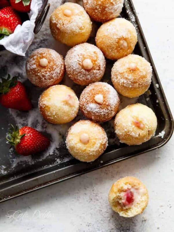 Lightened up soft and fluffy Strawberry Cheesecake Donut Holes, filled with sweet strawberry and creamy cheesecake filling! on a tray