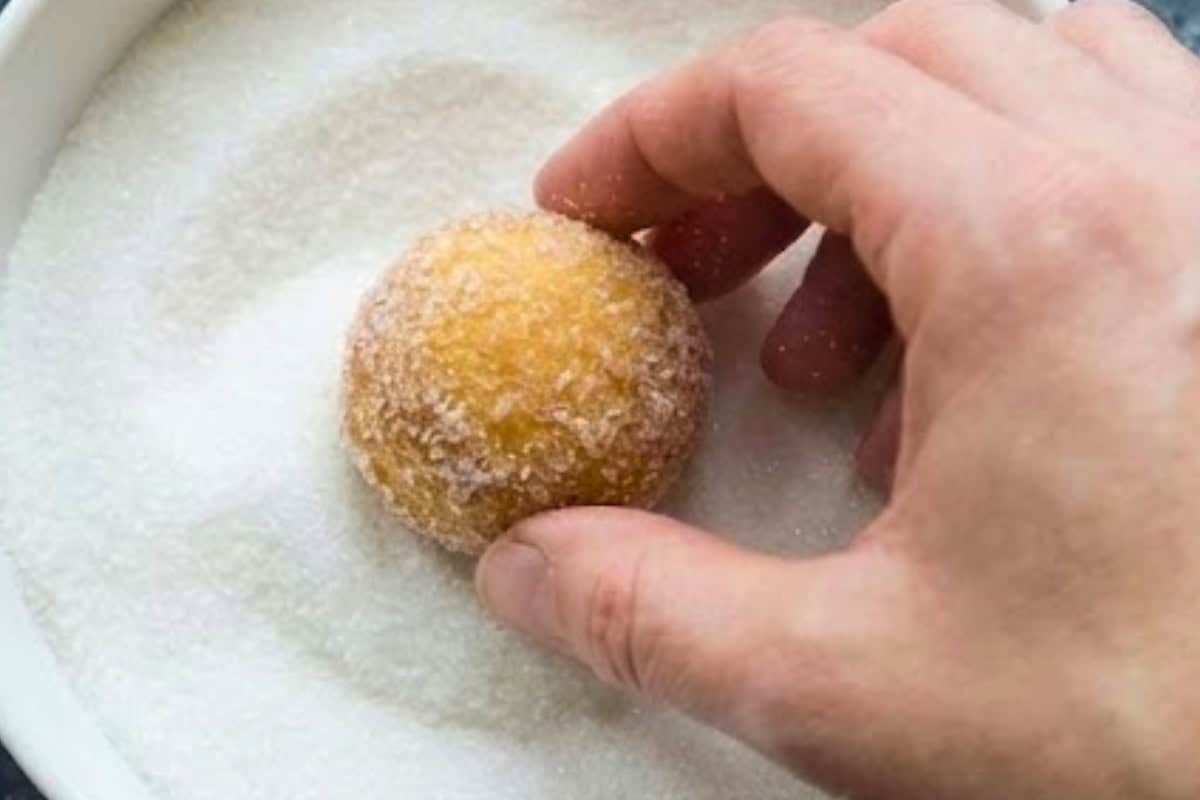 Allow the donut holes to cool for 5 minutes, then while still warm, gently roll each one in sugar until evenly coated