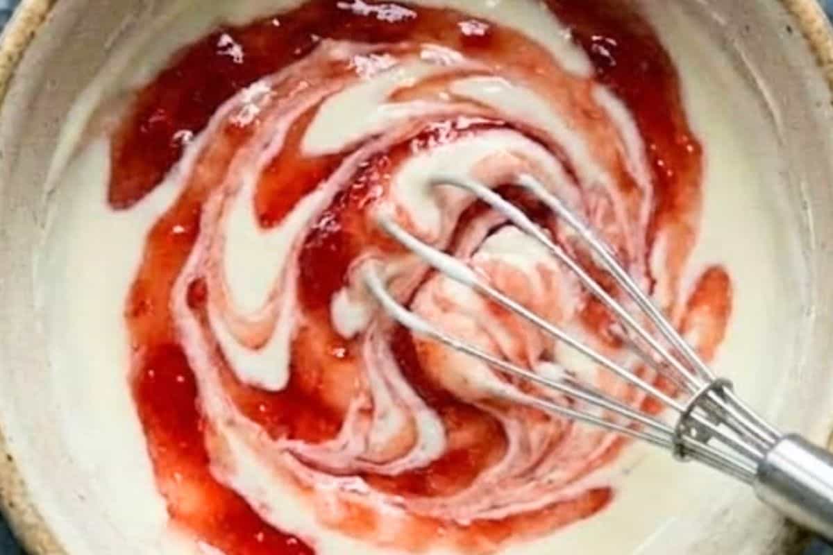 In a small bowl, beat the cream cheese and powdered sugar until smooth, then gently swirl in the strawberry jam to create a marbled effect without fully mixing.