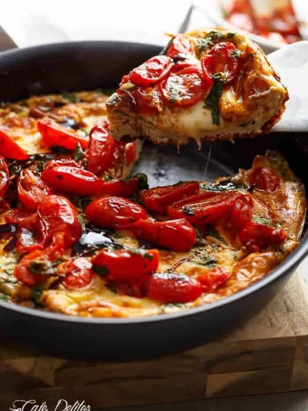 Garlic infused, Caprese Frittata with pan fried, juicy tomato and fresh basil flavors in a pan.