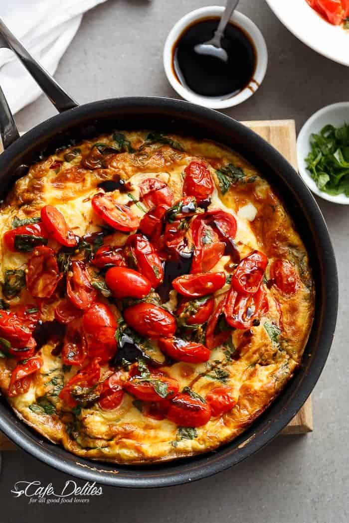 Garlic infused, Caprese Frittata with pan fried, juicy tomato and fresh basil flavors in a pan
