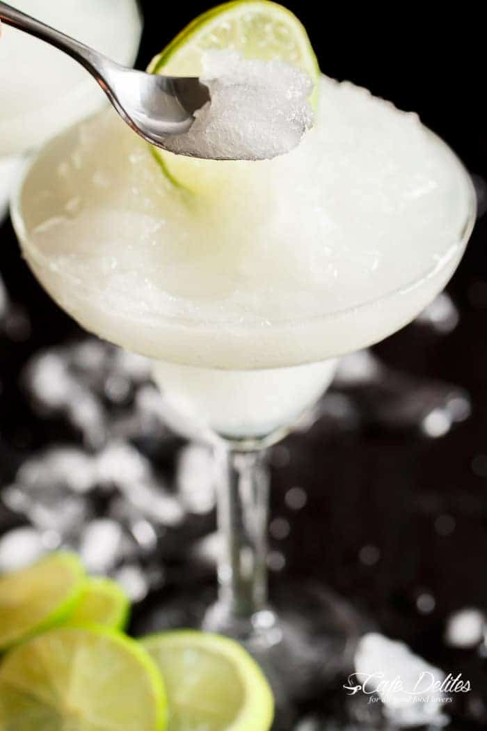 Zoom in image of a silver spoon scooping frozen slushy out of a cocktail glass.