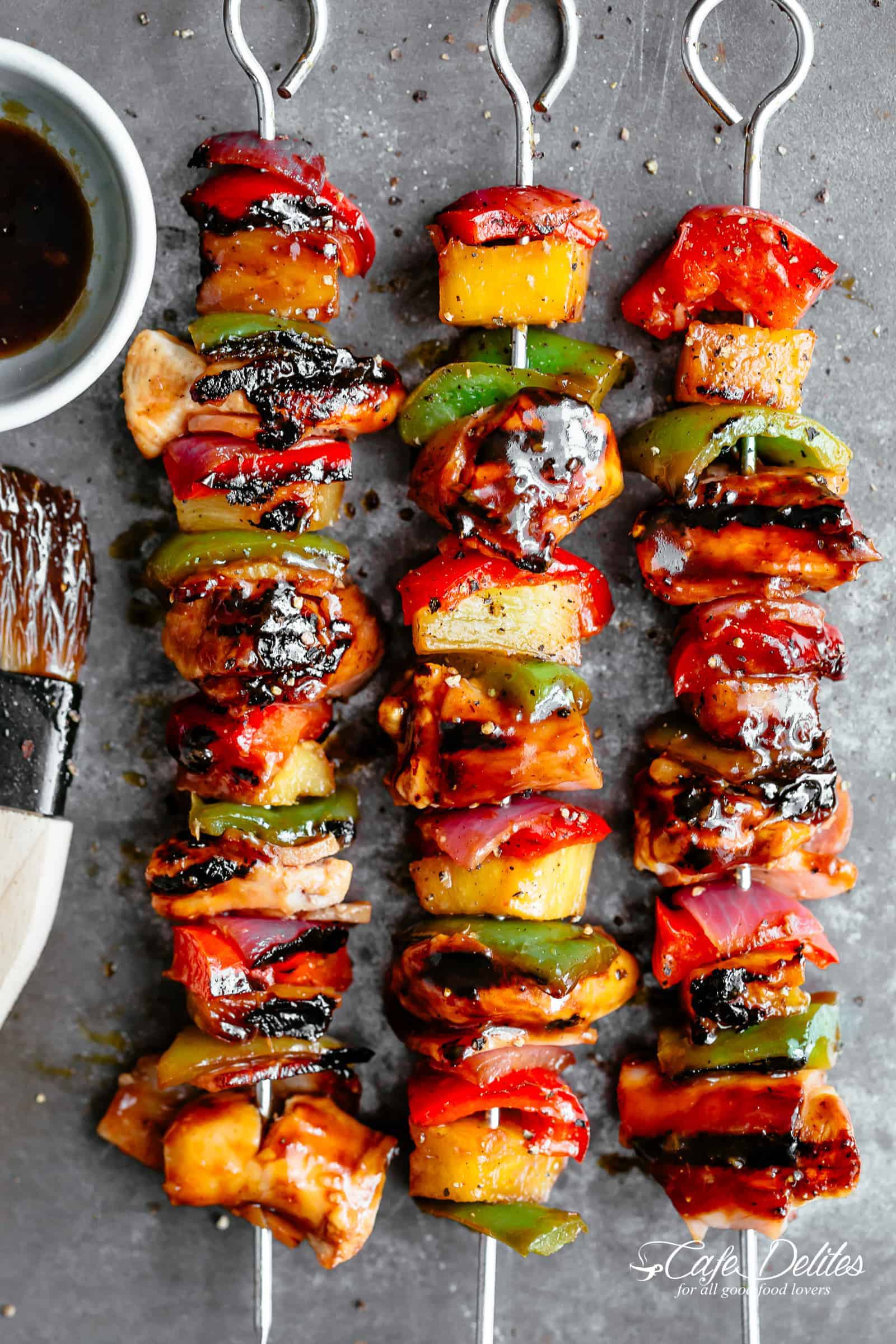 Grilled Chicken Kebabs with crispy bacon and chicken smothered in a garlicky-bbq sauce! | https://cafedelites.com Hawaiian Bacon Pineapple Chicken Kebabs with a BBQ twist! Crispy bacon and chicken smothered in a Hawaiian style pineapple and barbecue sauce