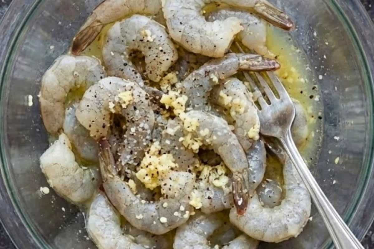 Place the shrimp in a shallow bowl with lemon juice, minced garlic, salt, and cracked pepper.
