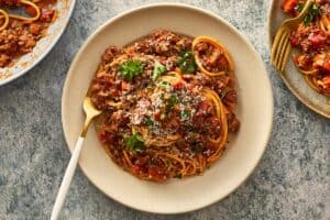 Finished spaghetti bolognese topped with parsley and parmesan