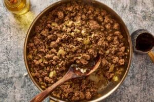 Ground beef browning in skillet with onions