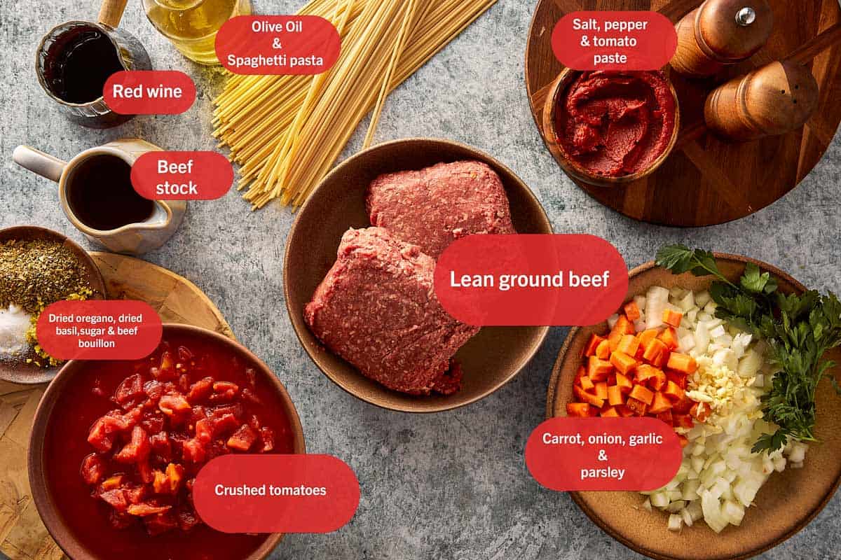 Overview photo of Slow Cooker Spaghetti Bolognese recipe ingredients including olive oil, onion, ground beef, garlic, beef stock, carrot, red wine, tomato paste, crushed tomatoes, oregano, basil, pepper, salt, parsley, sugar, beef bouillon, pasta