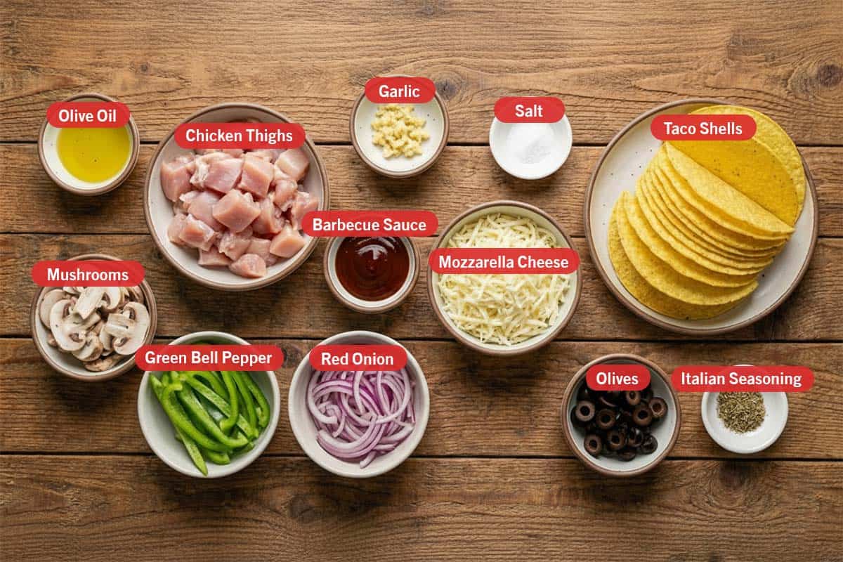 Top shot of ingredients: olive oil, chicken thighs, garlic, salt, taco shells, barbeque sauce, mozzarella cheese, mushrooms, green bell pepper, red onion, olives, and italian seasoning.